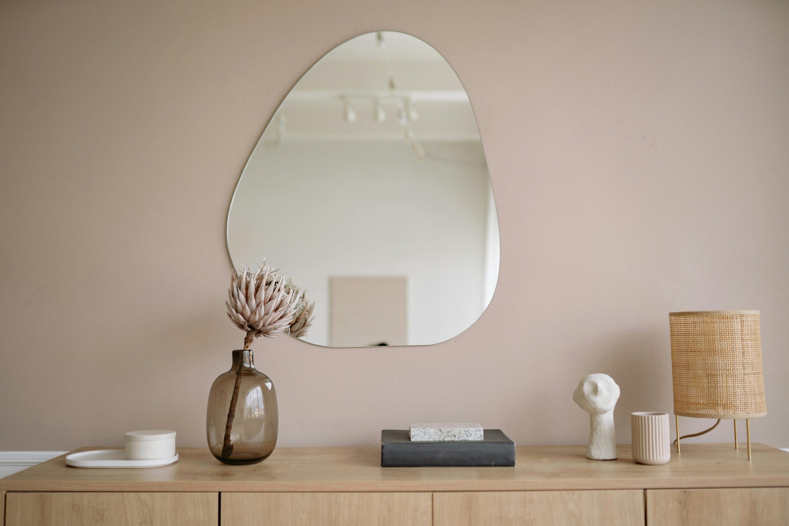 media console with irregular mirror hanging above