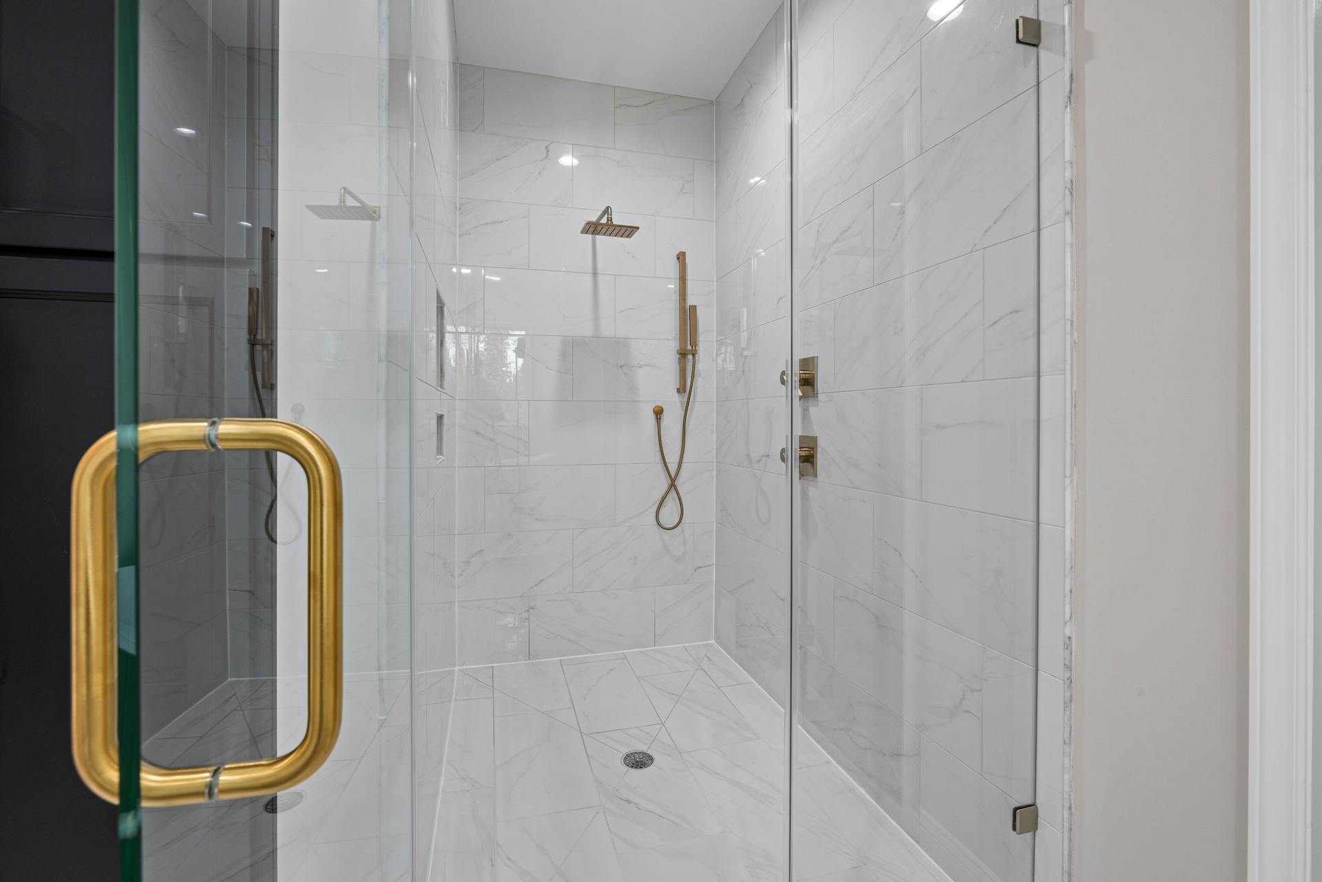 Bathroom Renovation Vancouver with white tiles and gold shower fixtures