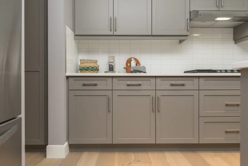 Grey kitchen cabinets with white subway tile backsplash.