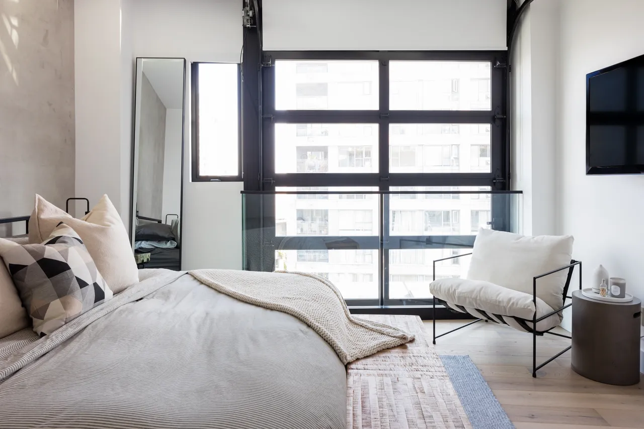 A bedroom with black sliding door and large mirror