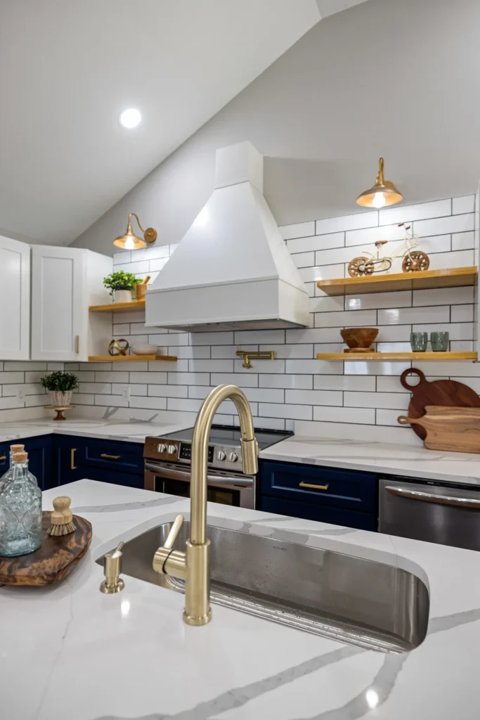 two tone navy and white kitchen with subway tiled backsplashes and gold fixtures