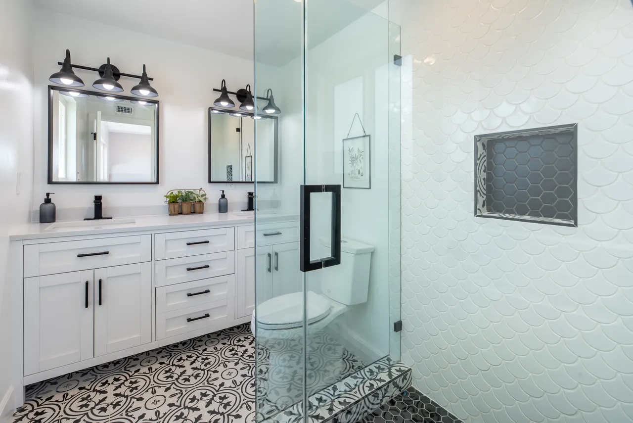 A bathroom with patterned floor tiles and double vanity