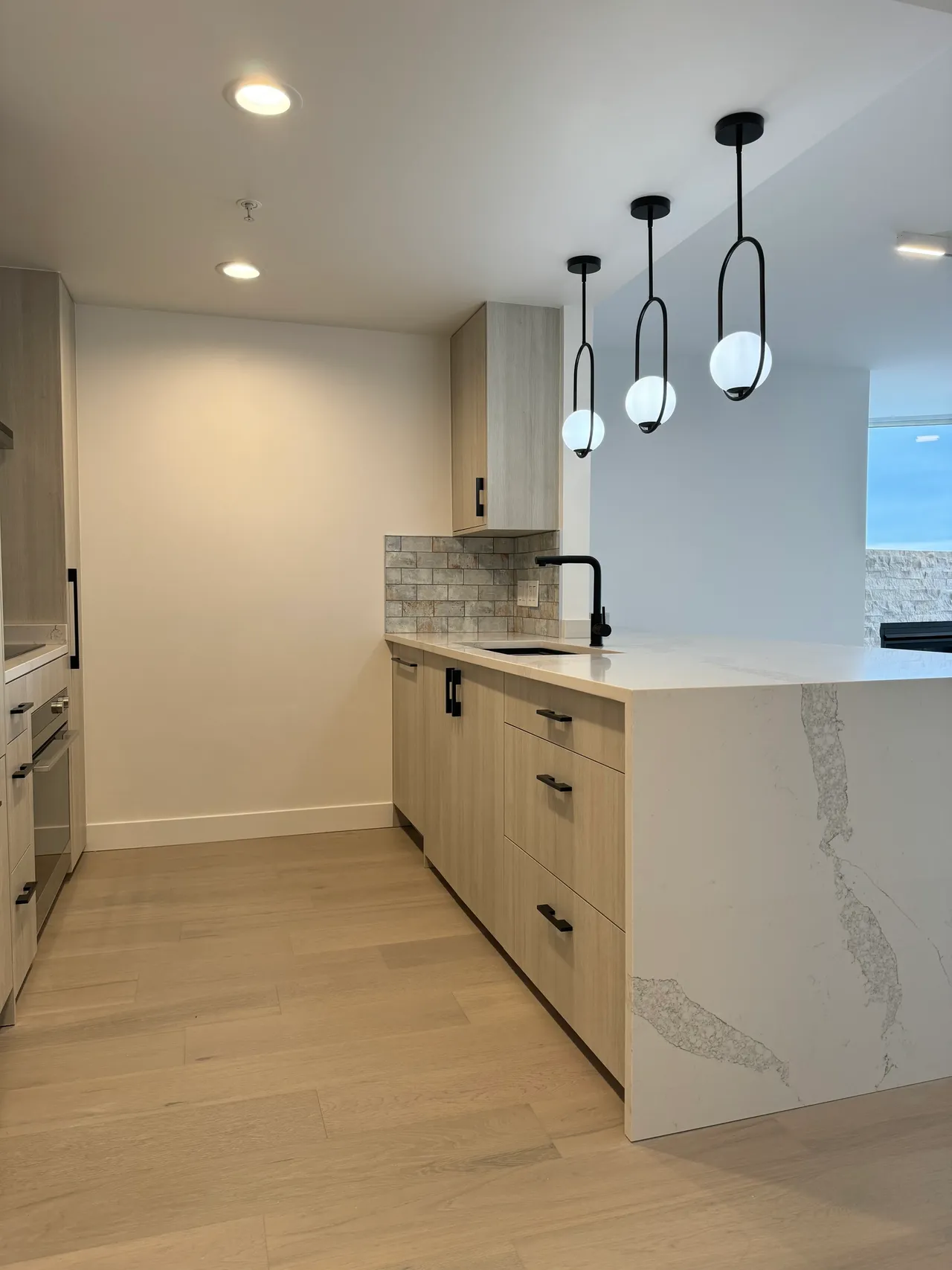 A yaletown kitchen with quartz countertops and engineered hardwood flooring