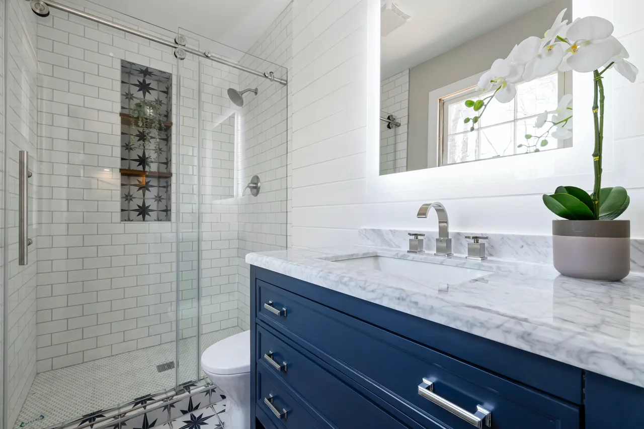 Shower with white subway tiles and blue bathroom vanity