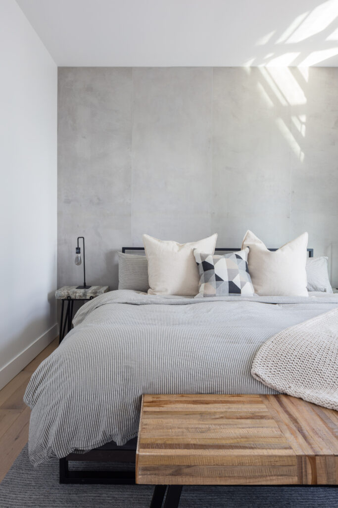 bedroom renovation by QUAY featuring concrete feature wall and hardwood flooring