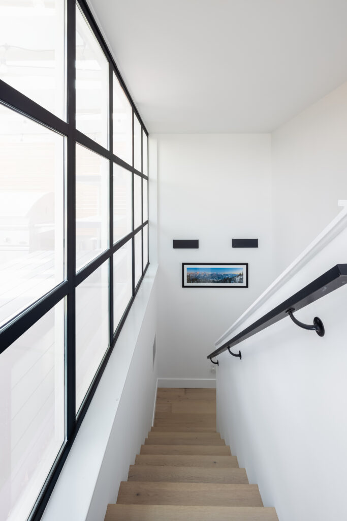 staircase with oak engineered hardwood flooring and black railings