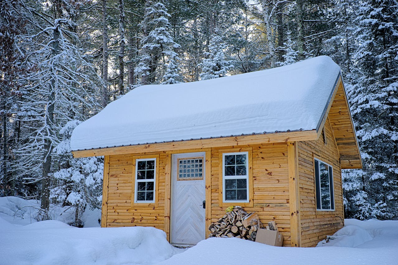 Snow-covered wooden house in the forest