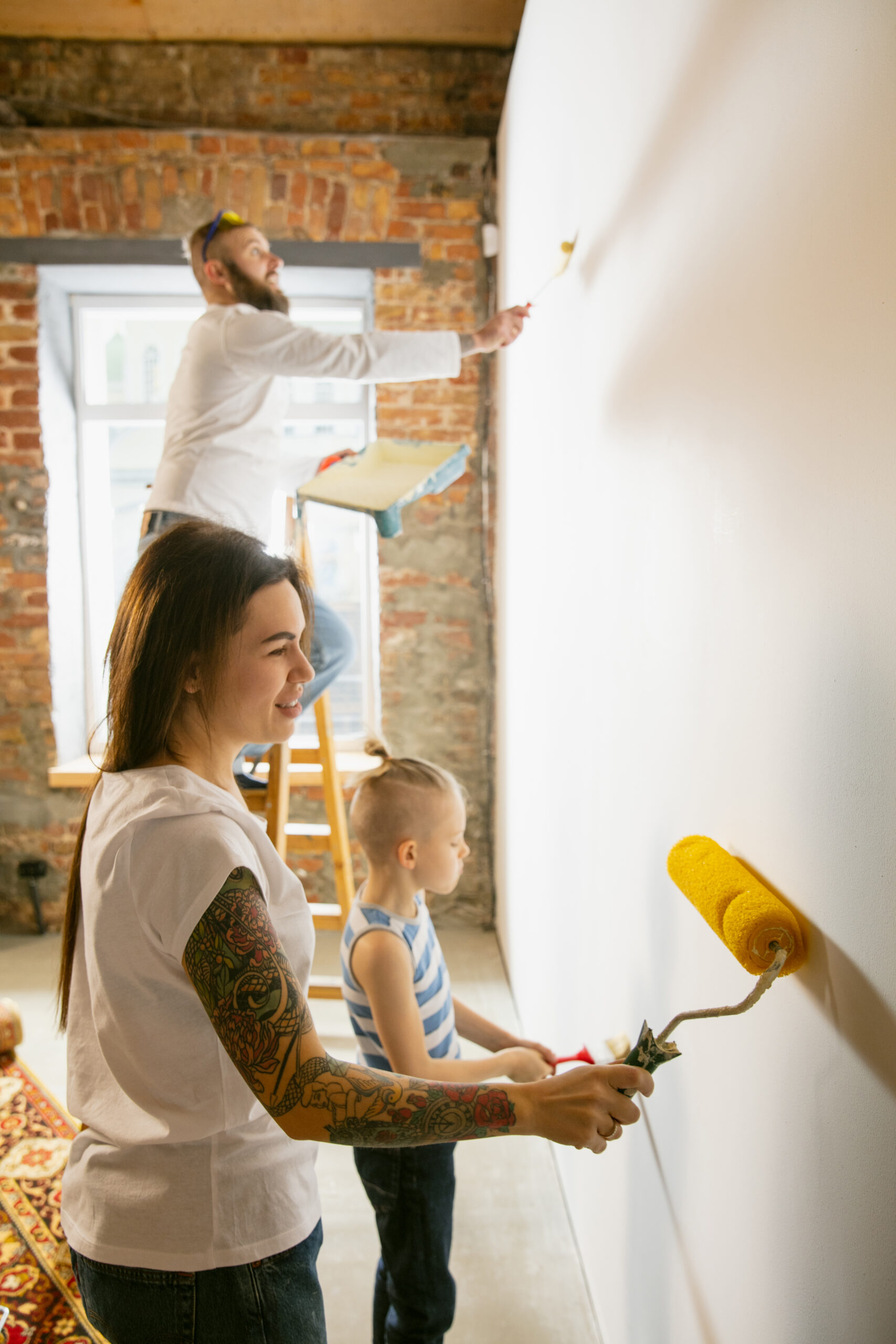 Young couple, family doing apartment repair together themselves. Mother, father and son doing home renovation in line with Vancouver condo renovation guidelines