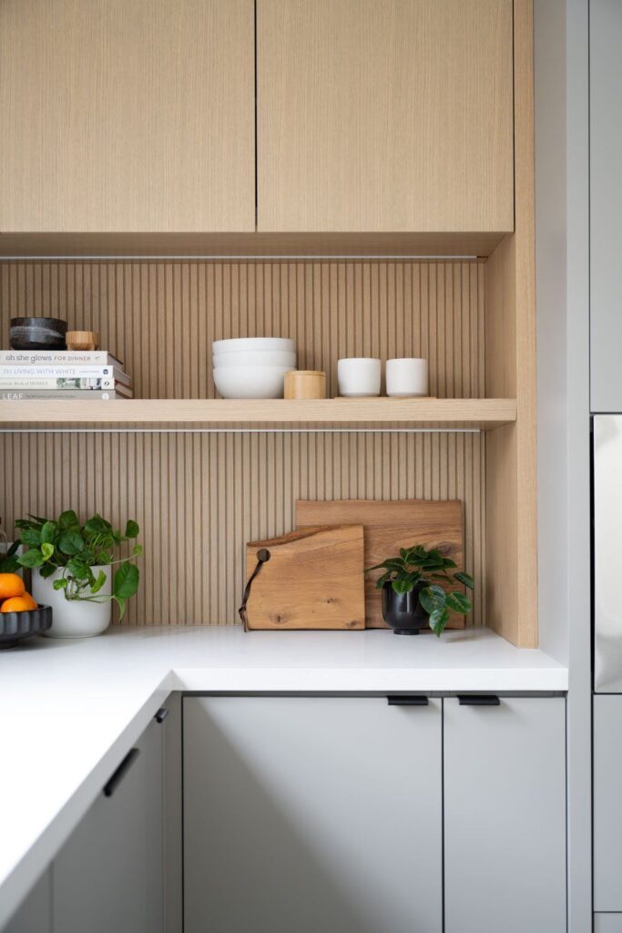 Close-up of custom kitchen cabinetry in Coquitlam featuring light wood paneling and built-in shelving, illustrating the need for detailed drawings in the permit application.