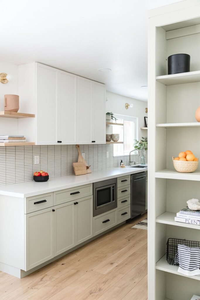 Full kitchen renovation in Coquitlam with two-toned cabinetry, a built-in microwave, and open shelving, representing a comprehensive project that requires detailed permit planning.