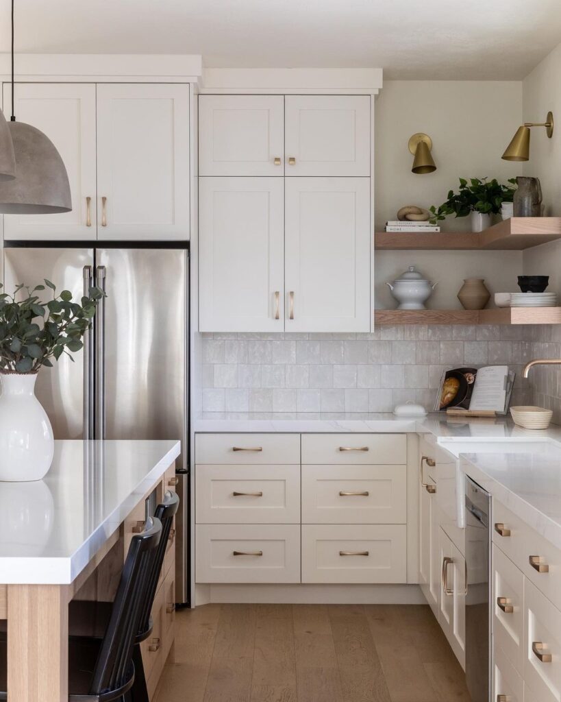 Coquitlam kitchen design featuring an L-shaped layout with white shaker cabinets, a wood island, brass hardware, and floating wood corner shelves.