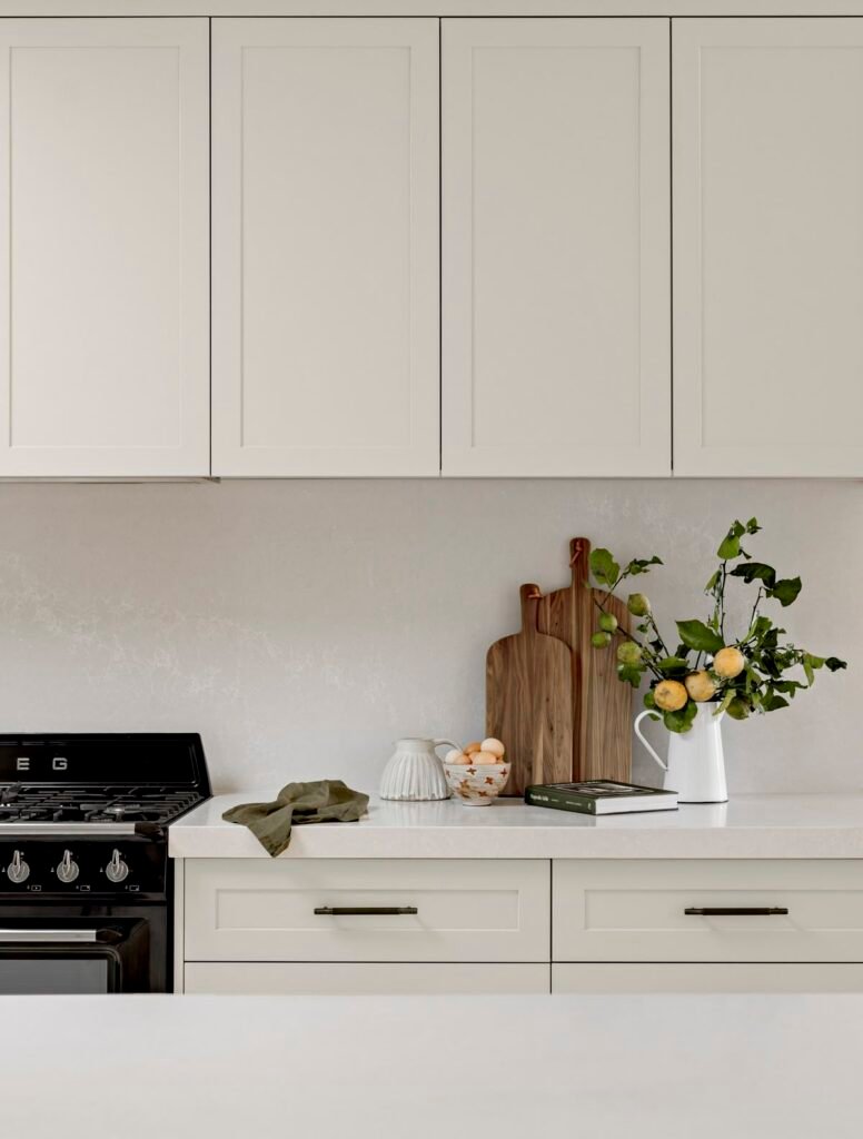 Minimalist Coquitlam kitchen renovation featuring light cabinets, quartz countertops, and a black SMEG range, representing the high-end cost range.