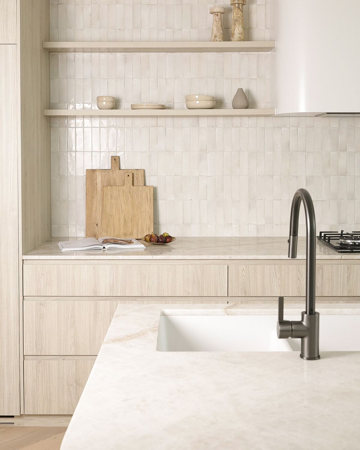 Modern Coquitlam kitchen design featuring light wood grain cabinetry, open shelving, marble countertop, and white vertical stacked subway tile backsplash.