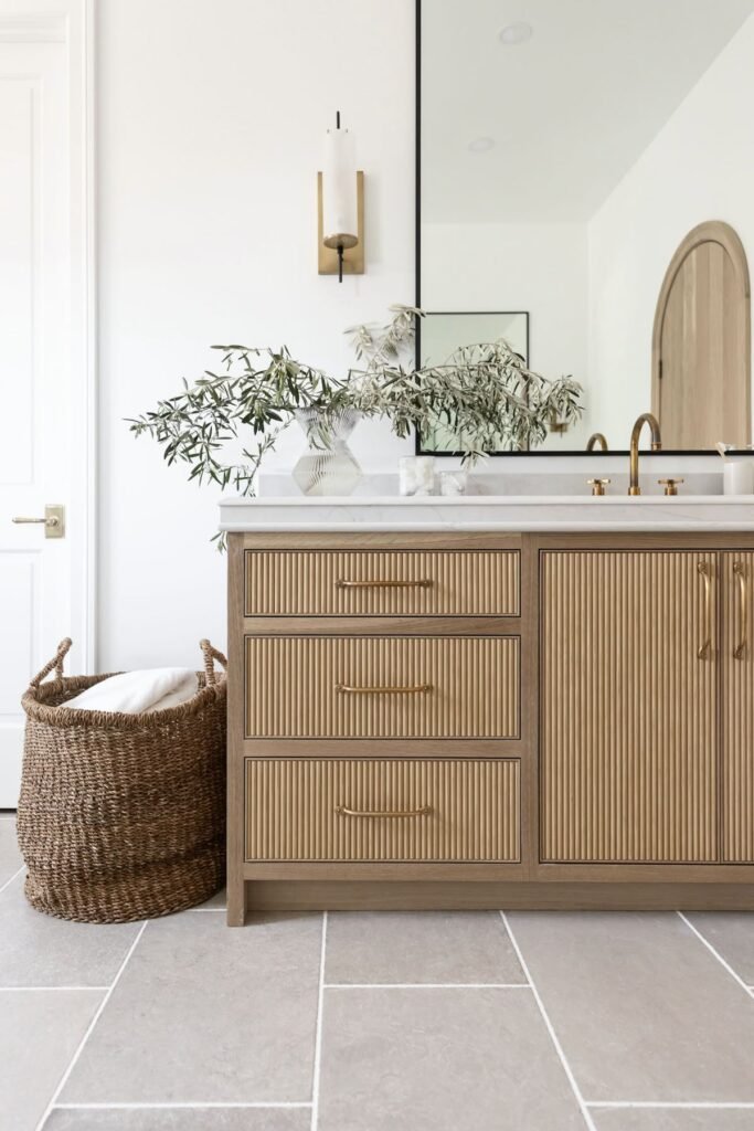 West Vancouver powder room renovation with textured natural wood vanity, brushed gold fixtures, and large format tile flooring