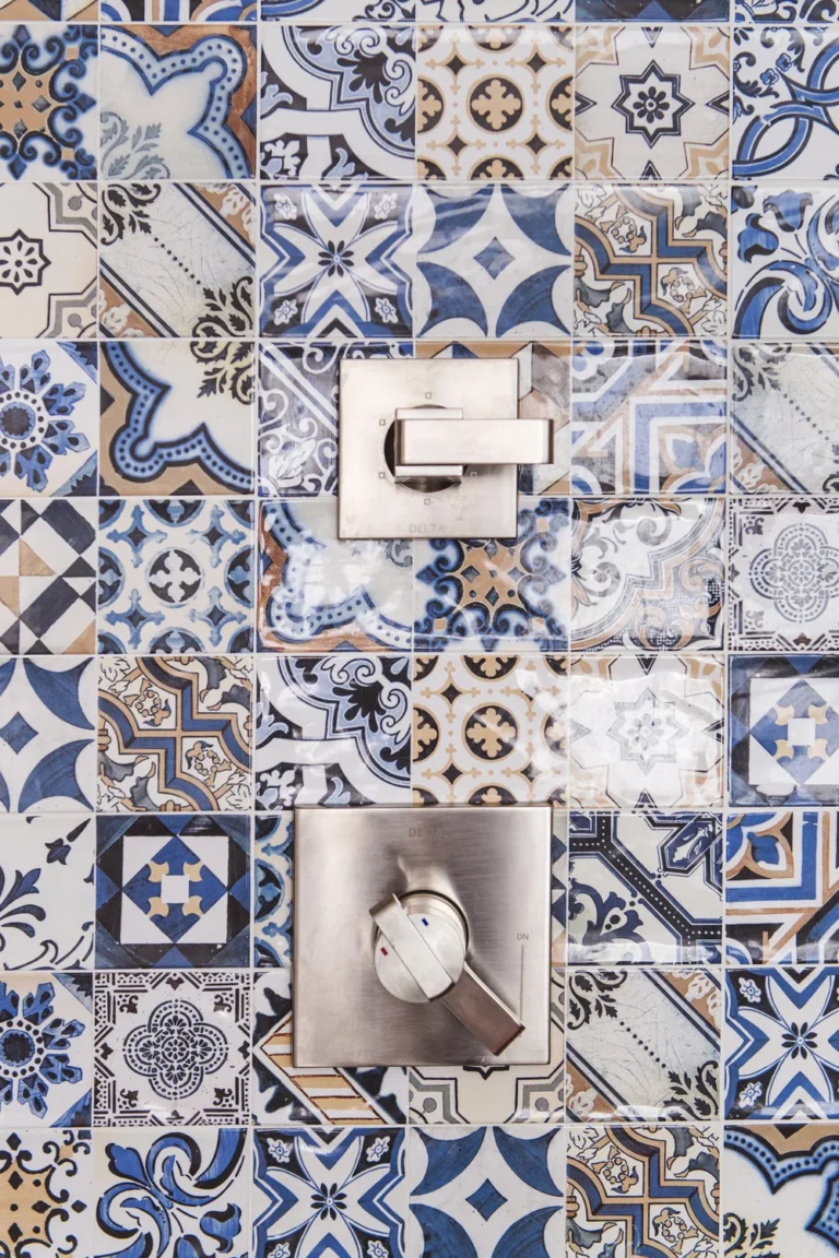 Luxury shower renovation in Mount Pleasant featuring blue and white patterned Mediterranean-style tiles with brushed nickel Delta fixtures.