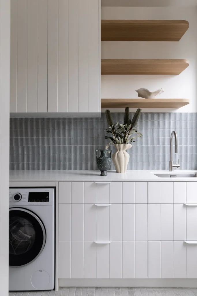 Modern laundry room with white fluted cabinetry and grey kit-kat tile backsplash from a professional home renovation in Brighouse by Quay Construction