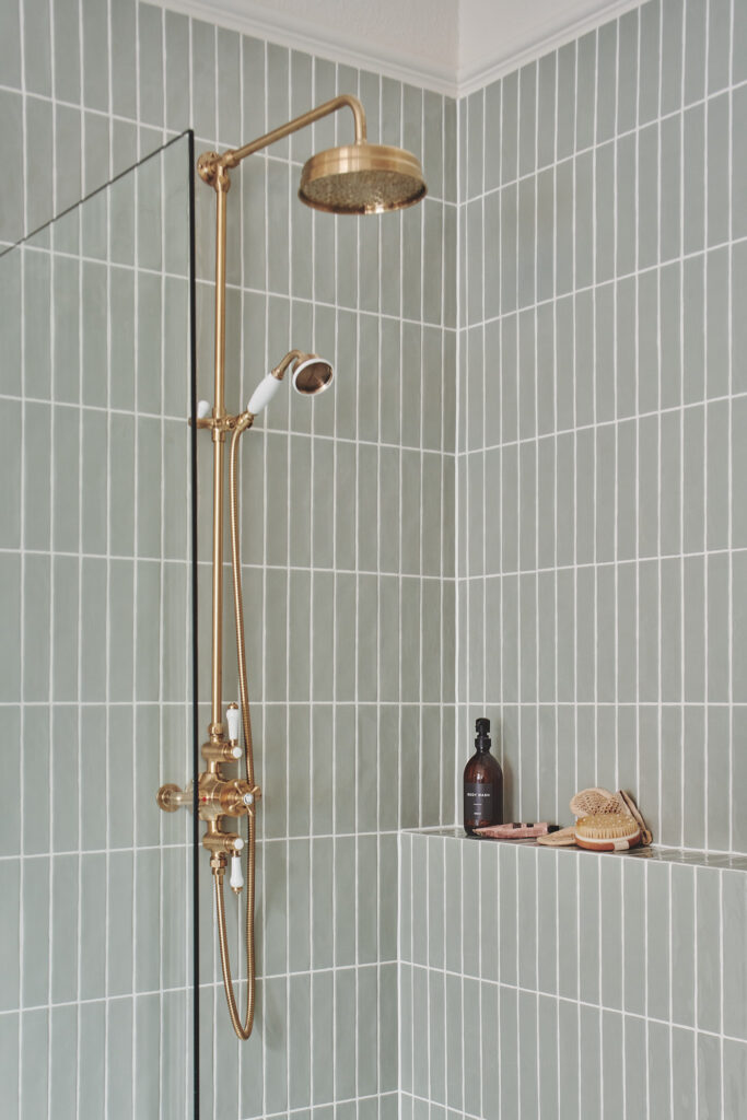 Luxury West Vancouver bathroom renovation with brass rainfall shower system and sage green vertical tile