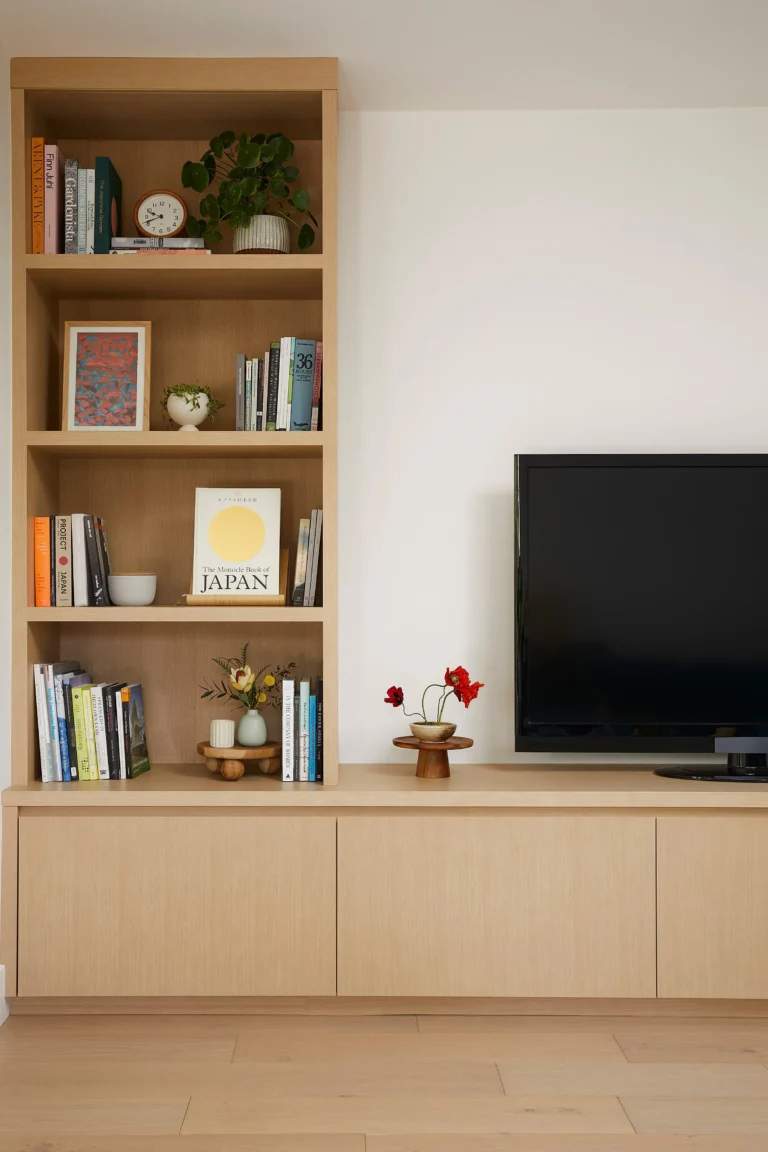 Bespoke light oak Japandi-style built-in bookshelf and media console with minimalist decor in an Ambleside home.