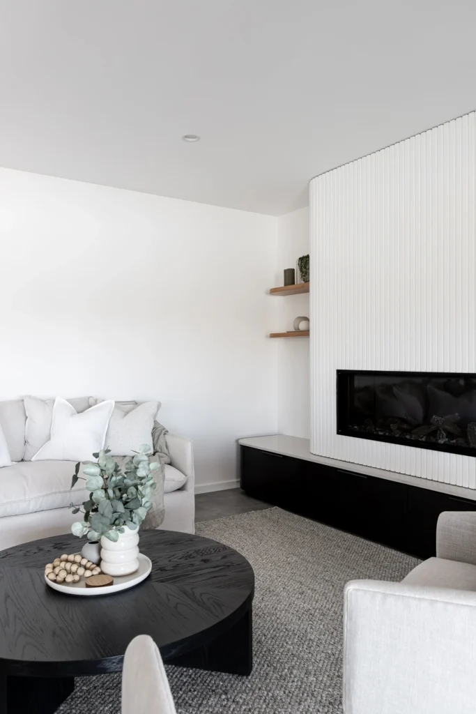 Finished basement living and dining area by Quay Construction in Vancouver, featuring modern grey flooring, recessed lighting, and a white dining set.