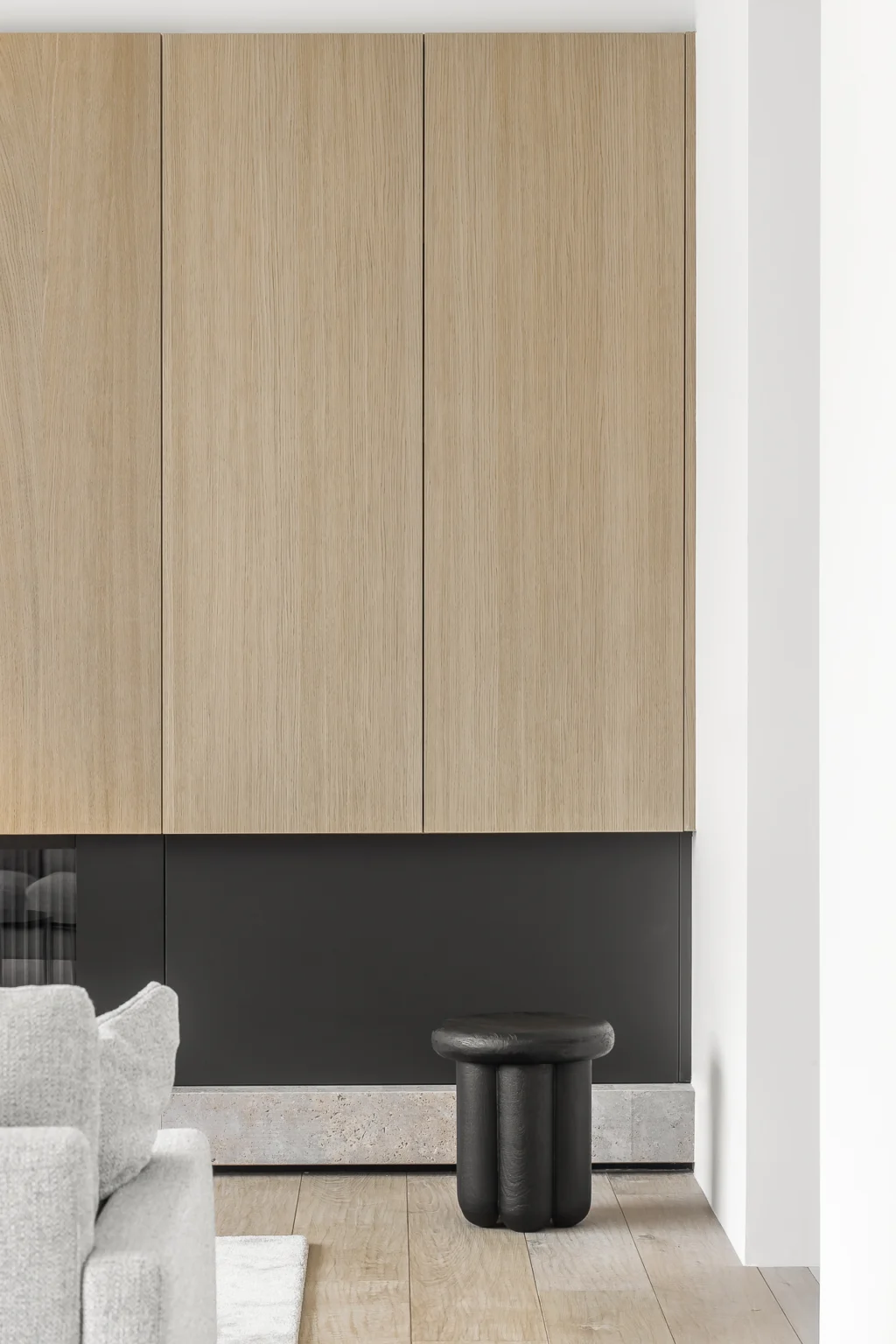 Luxury condo renovation by Quay Construction in Vancouver featuring floor-to-ceiling white oak custom cabinetry above a modern black accent wall.