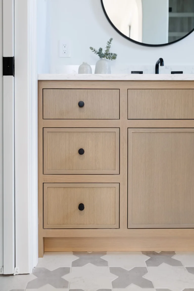 Modern Dundarave bathroom renovation featuring a custom white oak vanity, matte black hardware, and geometric patterned floor tile.