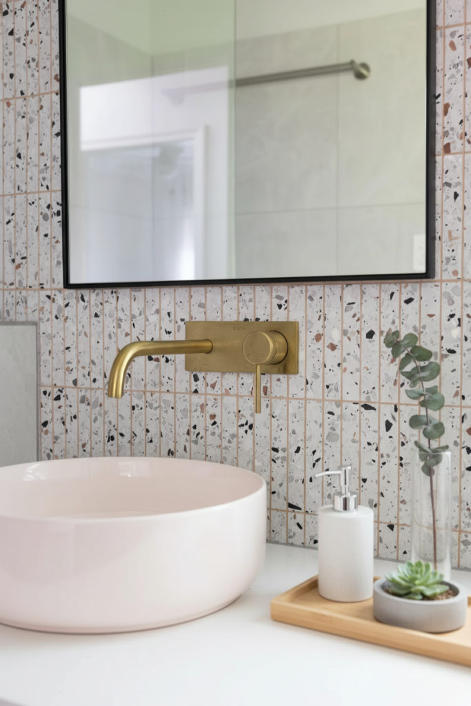 Detalle de renovación de baño en Surrey por QUAY Construction con pared de piedra estriada y accesorios negros.