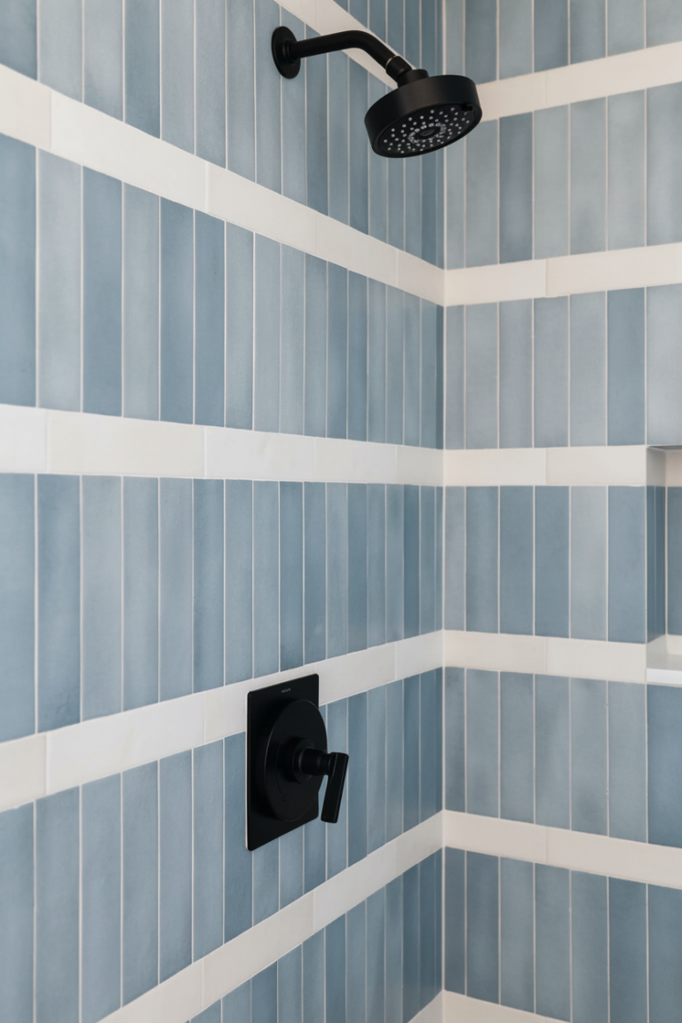 Detalle de renovación de baño en Richmond por QUAY Construction con pared de piedra estriada orgánica, accesorios negros mate y encimera de mármol