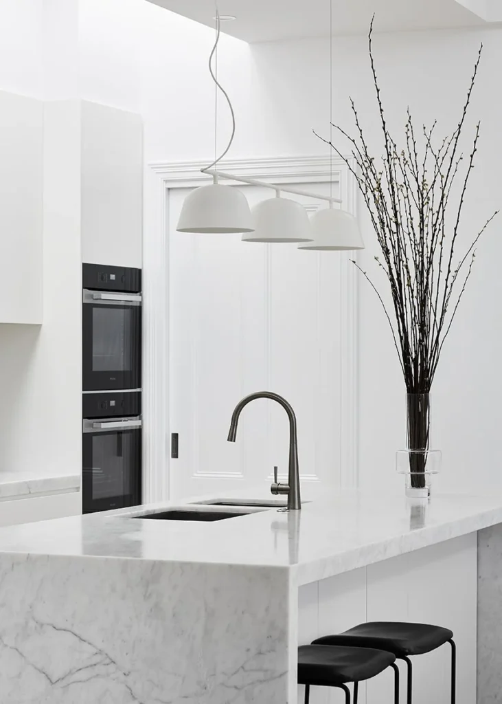 Modern waterfall marble island featuring integrated sink in a luxury kitchen renovation Vancouver by QUAY Construction.