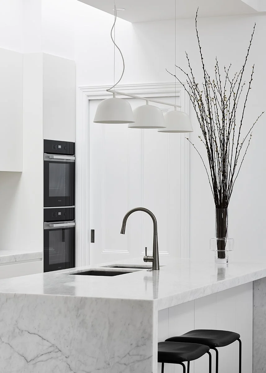 Modern waterfall marble island featuring integrated sink in a luxury kitchen renovation Vancouver by QUAY Construction.