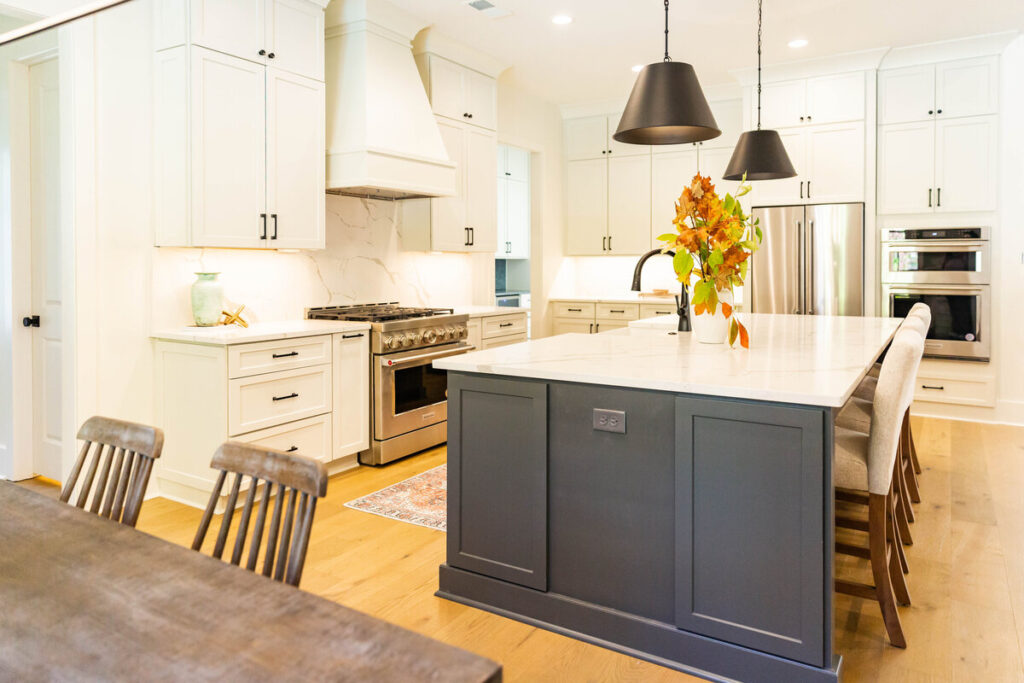 Modern kitchen renovation in Coquitlam by QUAY Construction featuring light oak floating shelves, glossy white square tile backsplash, and olive green cabinetry.