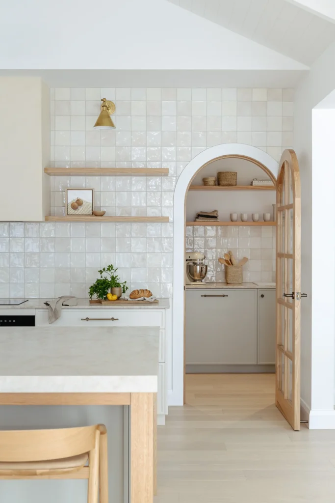 Modern living room area from a kitchen renovation in Surrey by QUAY Construction featuring a black fireplace and custom oak shelving.