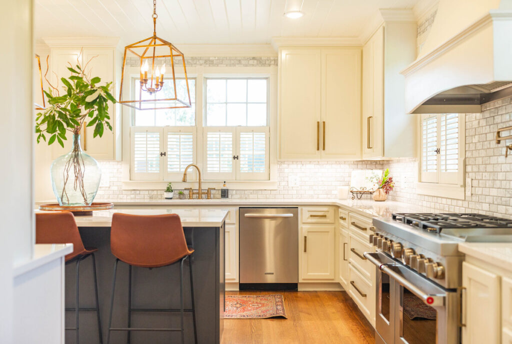 Modern kitchen renovation Vancouver with white cabinetry, marble backsplash, and gold lantern pendant lighting.