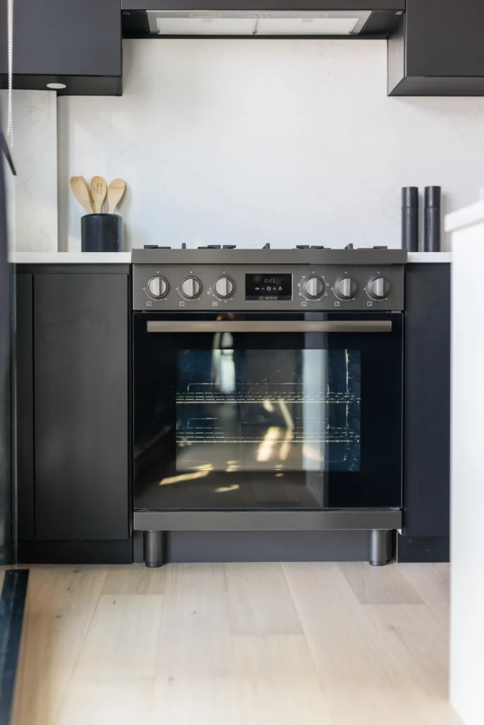 Modern kitchen renovation in Vancouver featuring white upper shaker cabinets and navy blue lower cabinetry.
