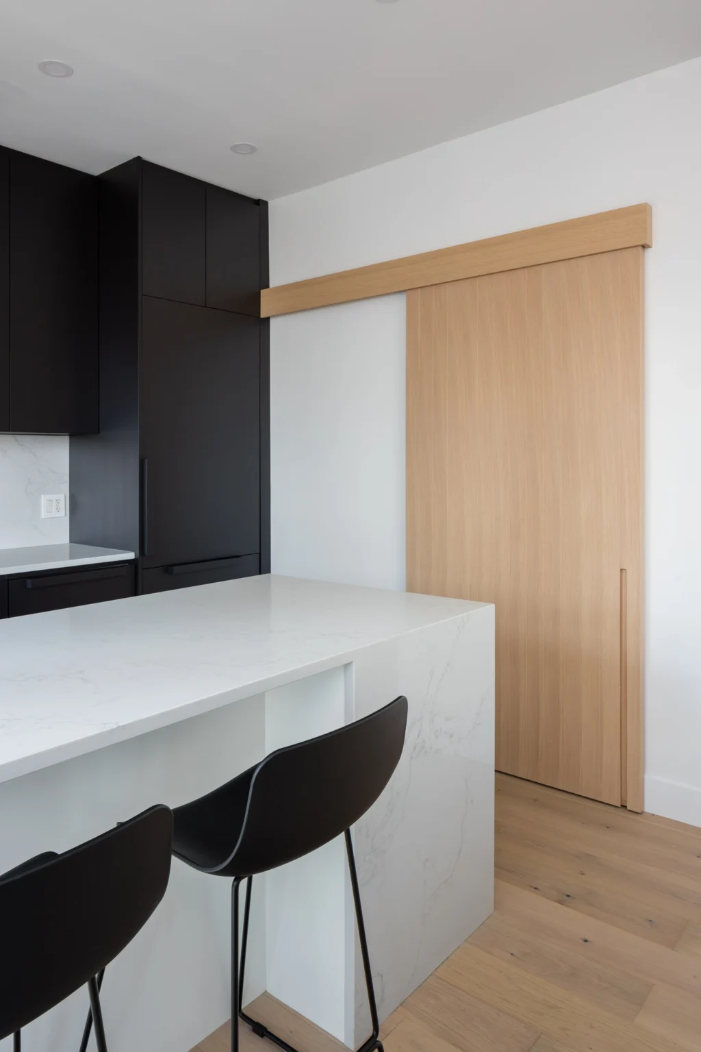 Designers and homeowners reviewing kitchen cabinet door styles in a Vancouver showroom consultation.