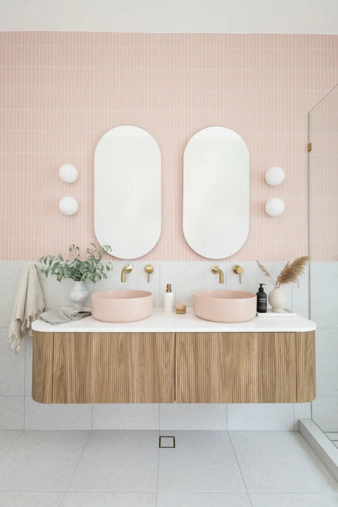 Modern West End bathroom renovation featuring pink vessel sinks, gold faucets, and a fluted wood floating vanity.