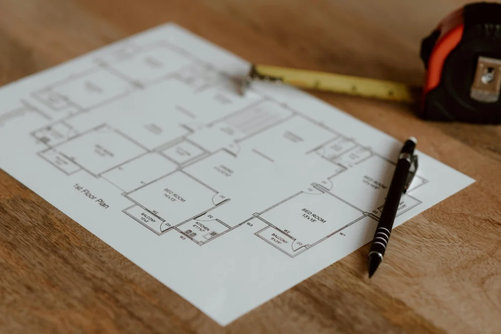 Architectural floor plan with measuring tape, focusing on renovation scheduling and Vancouver contractor availability.