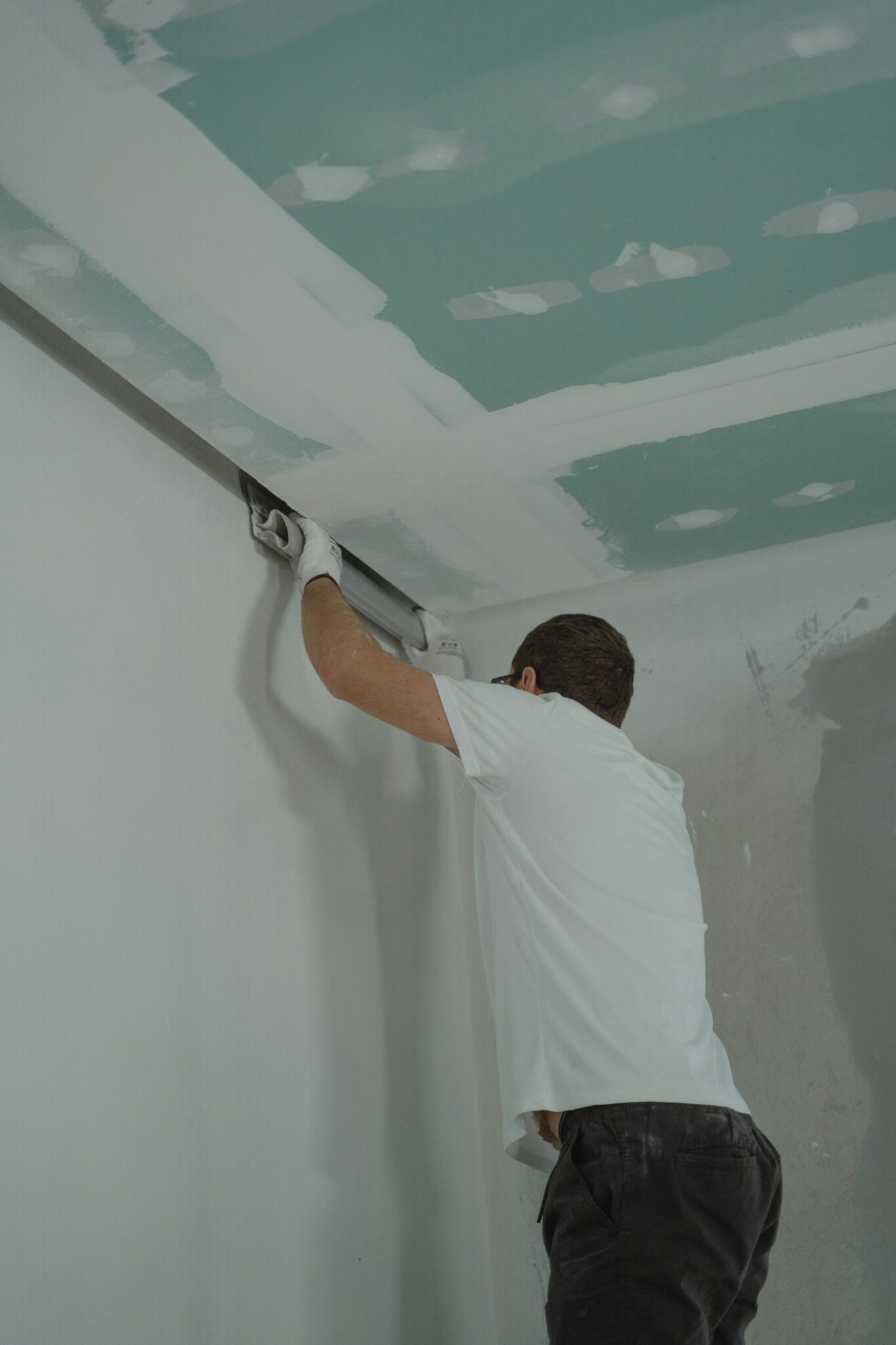 Professional contractor finishing drywall during a kitchen renovation Vancouver project for a seamless, luxury finish.
