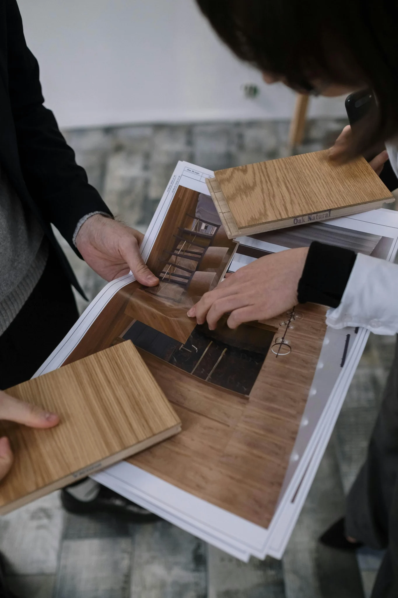 Designers reviewing natural oak flooring samples for a luxury kitchen renovation Vancouver project by QUAY Construction.