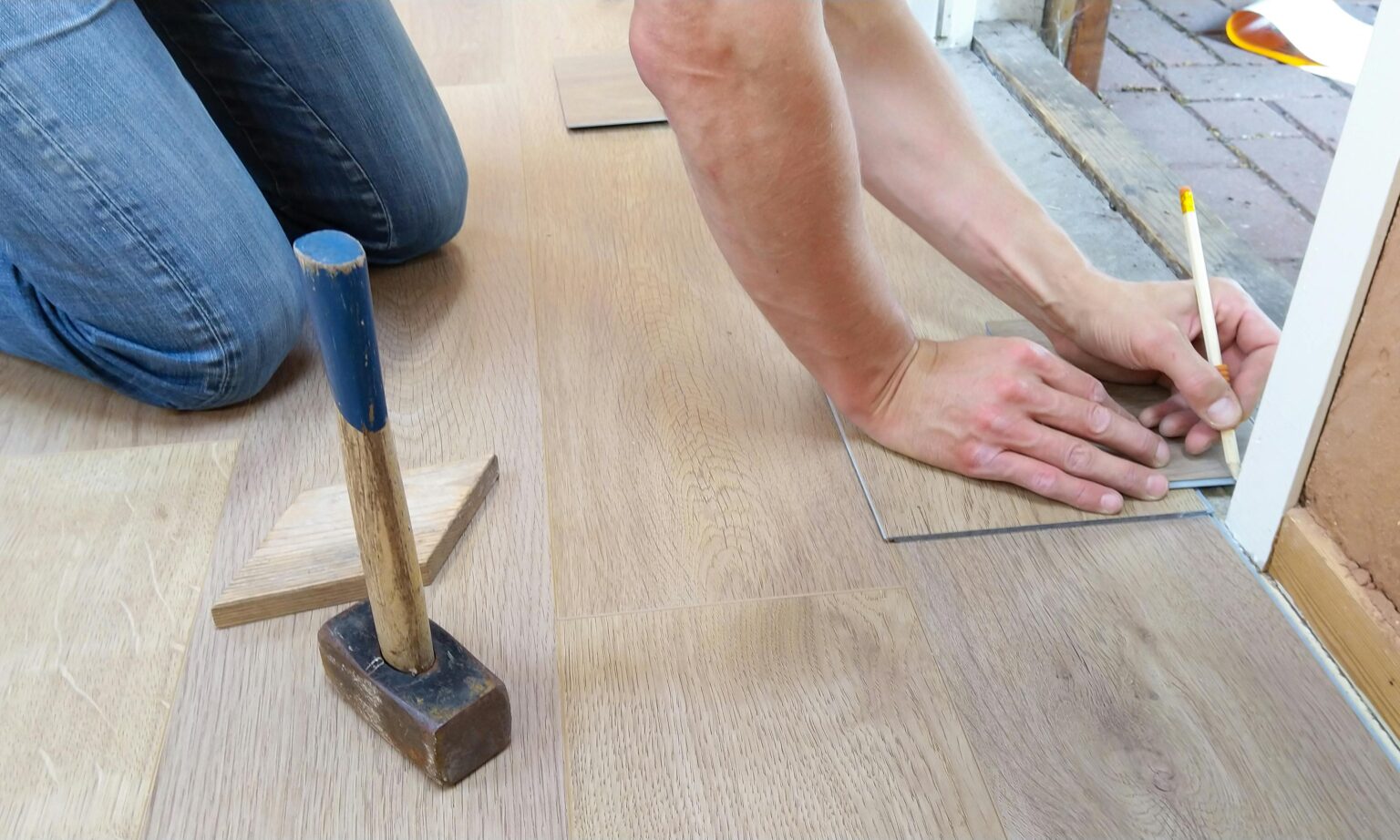 Contractor measuring and cutting kitchen flooring options in Vancouver for a precise custom fit.