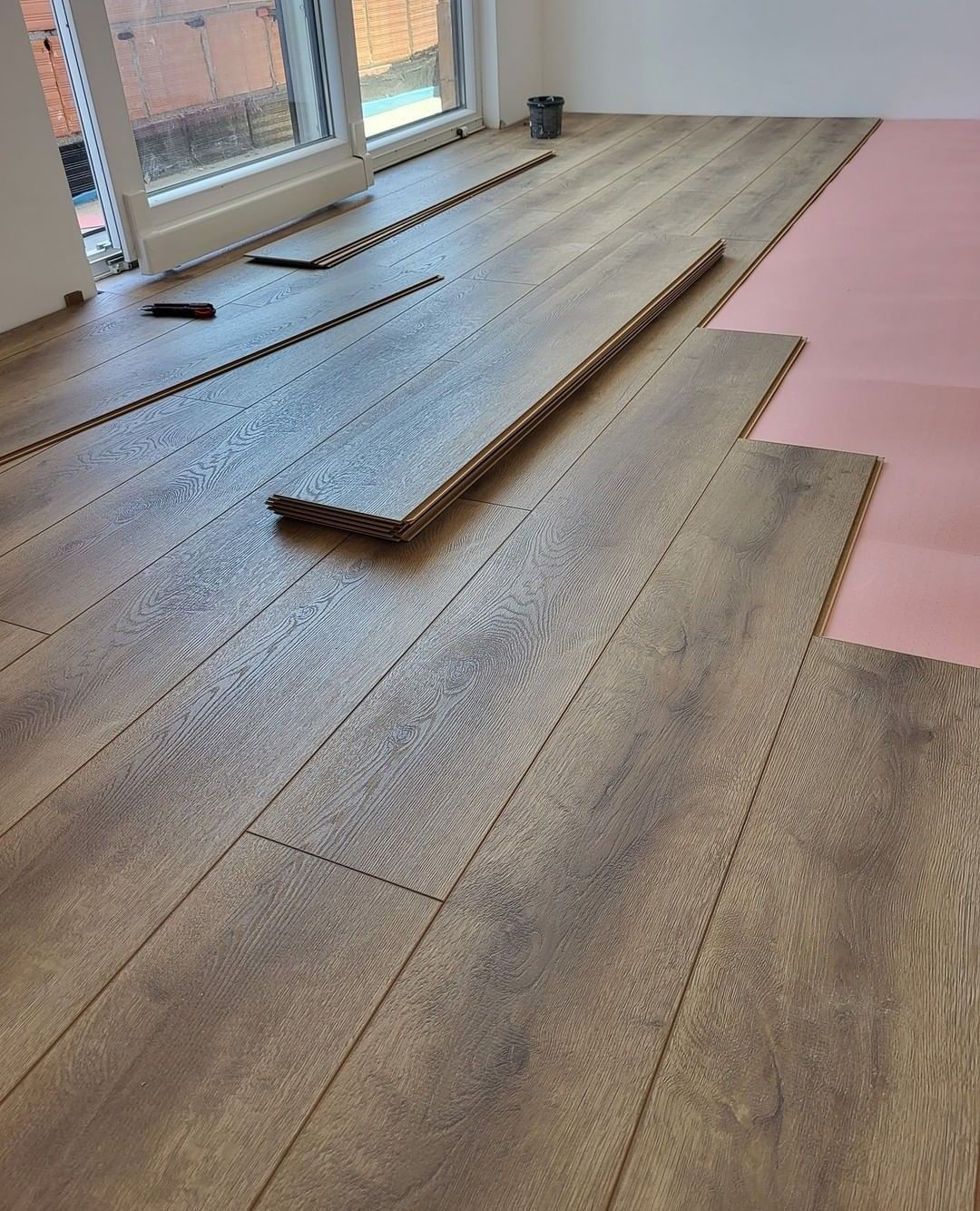 Professional installation of wide-plank kitchen flooring options in Vancouver over protective underlayment.