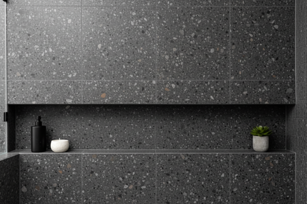 Modern bathroom renovations Vancouver bc featuring a recessed shower niche with dark grey terrazzo tile and bath products.