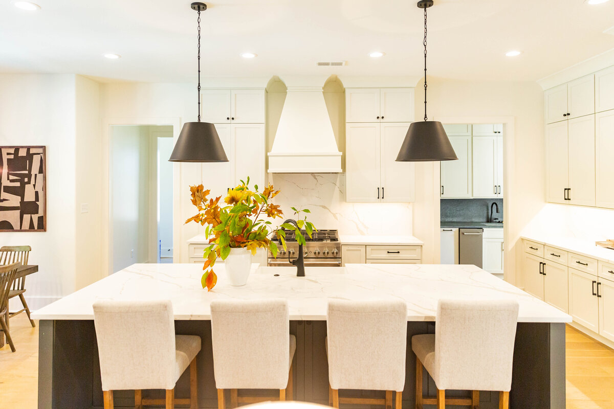 Detalle de renovación de baño en Coquitlam por QUAY Construction con pared de piedra estriada y accesorios negros.