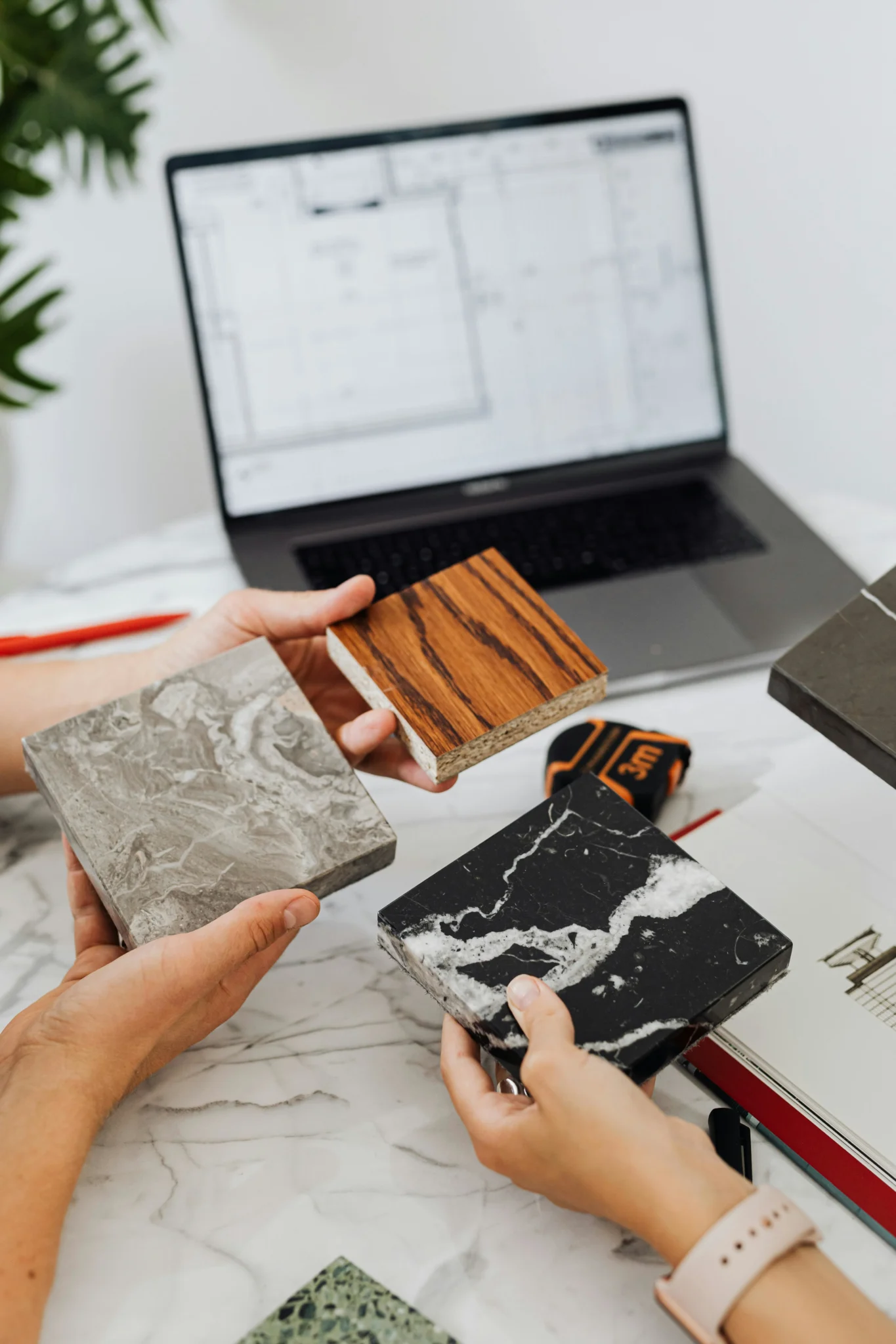 Architectural material samples including marble and wood being reviewed to avoid renovation change orders Vancouver.