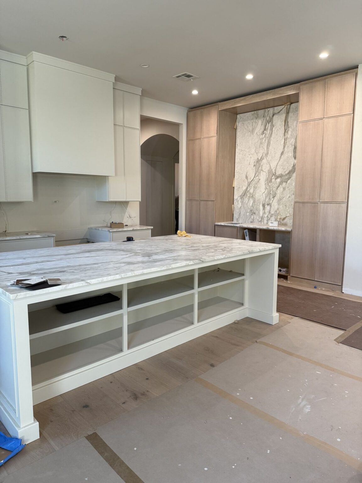 Kitchen renovation project management Vancouver showing marble island and custom cabinetry installation progress.