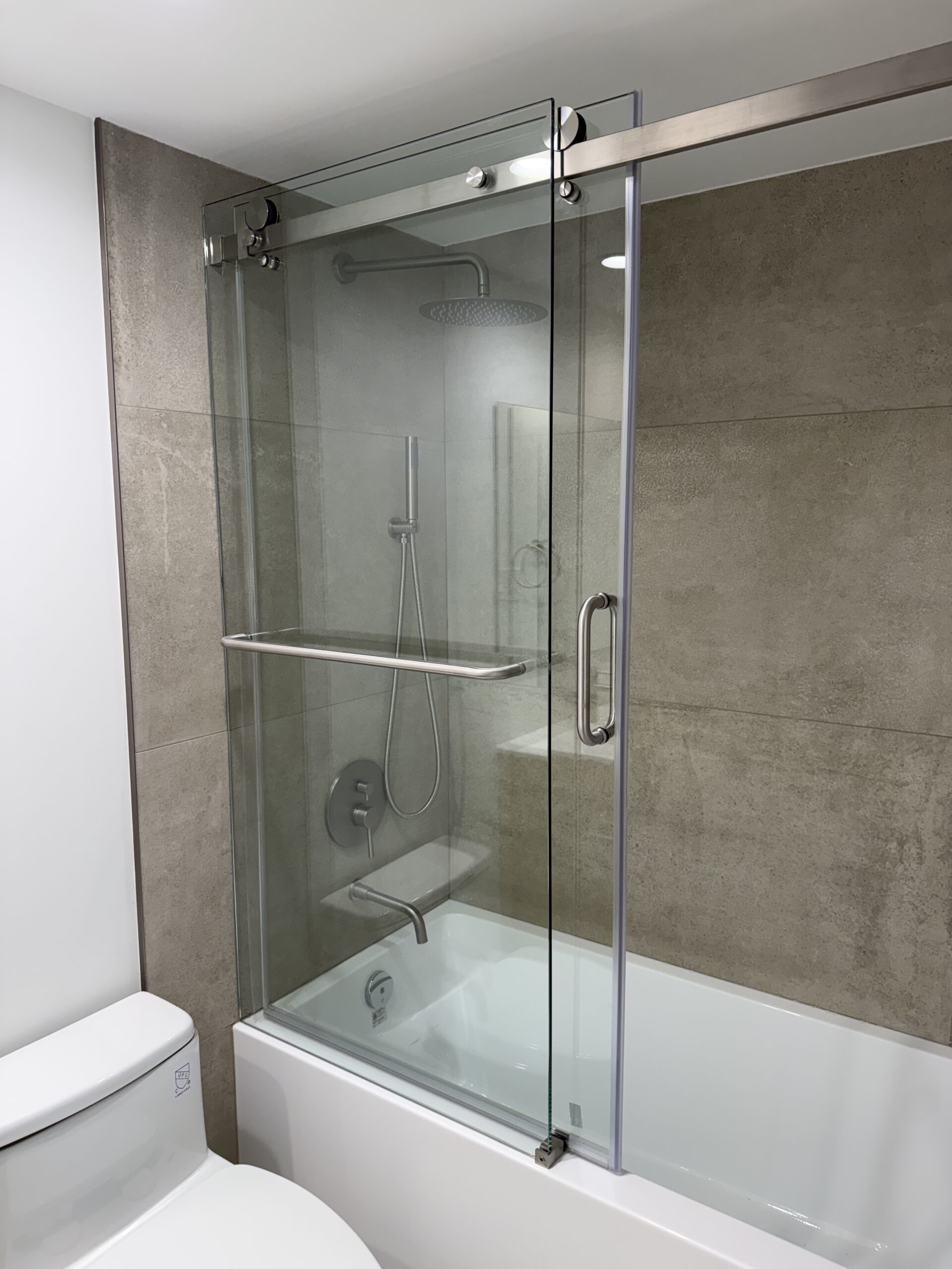 Frameless glass shower enclosure with large-format porcelain tile in Yaletown condo bathroom renovation