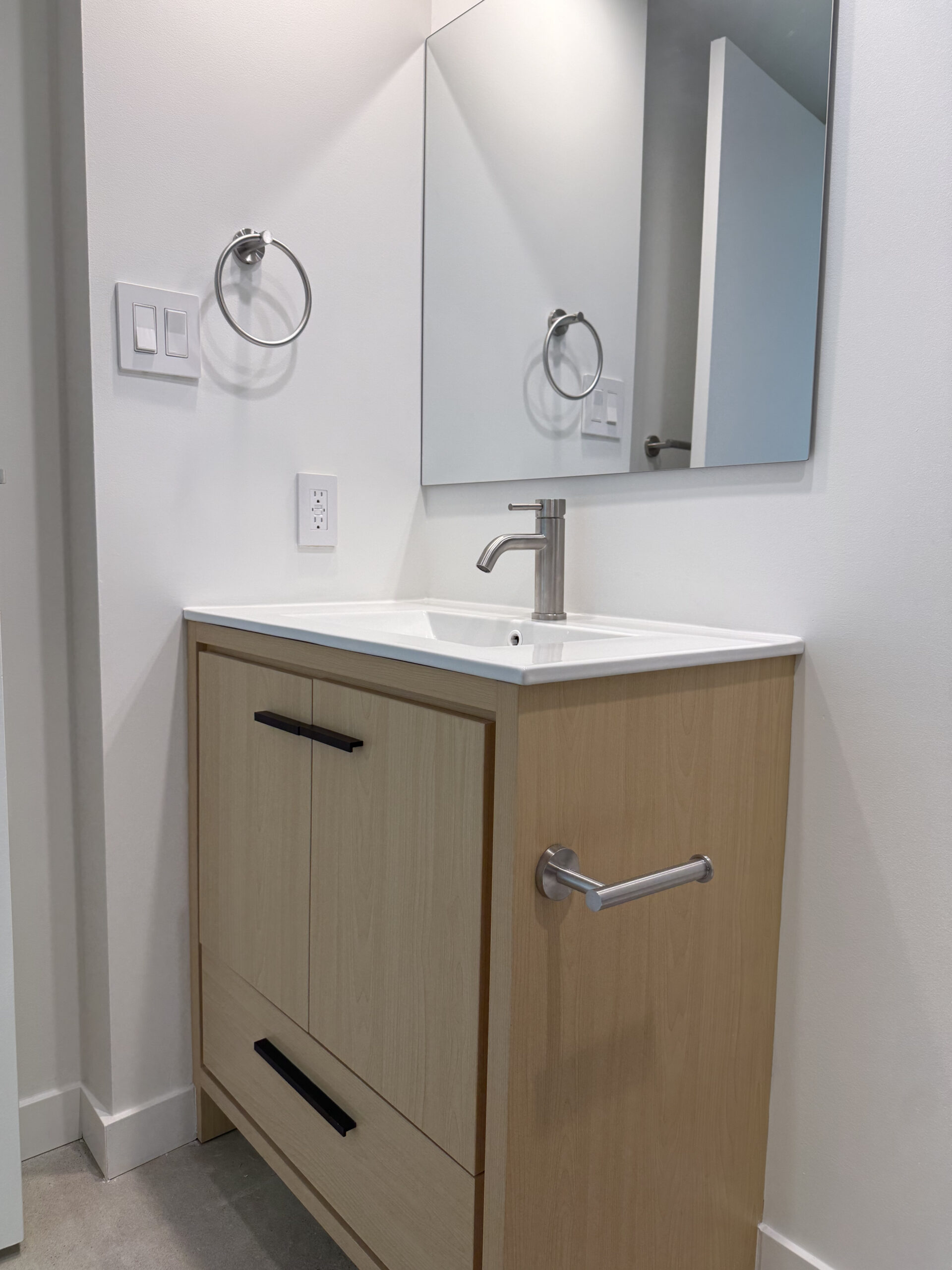 Custom wood-tone vanity with integrated sink in Yaletown condo bathroom renovation
