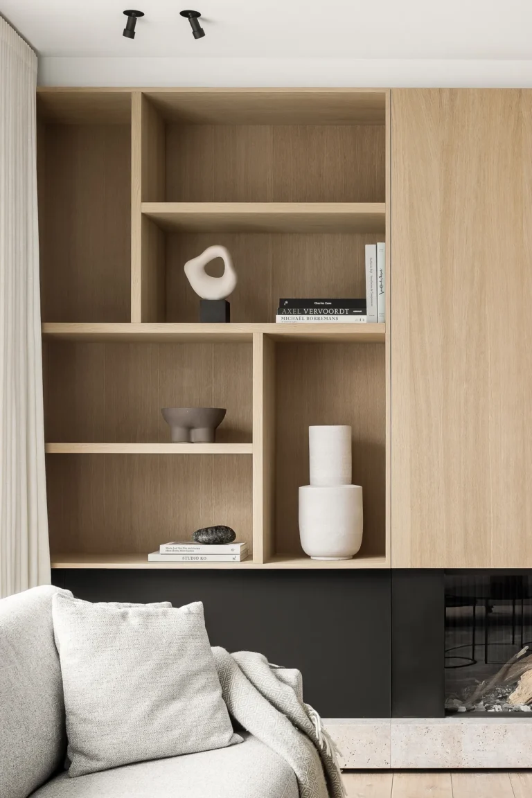 Modern living area from a condo renovation in Coquitlam by QUAY Construction featuring a black fireplace and custom oak built-ins.