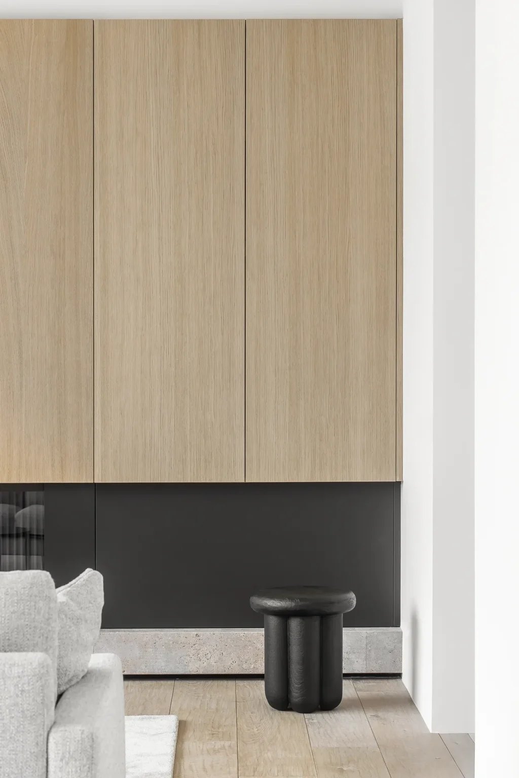 Luxury condo renovation by Quay Construction in Vancouver featuring floor-to-ceiling white oak custom cabinetry above a modern black accent wall.