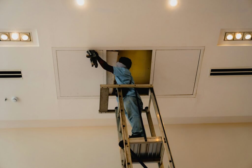 Professional working on a ceiling from a ladder