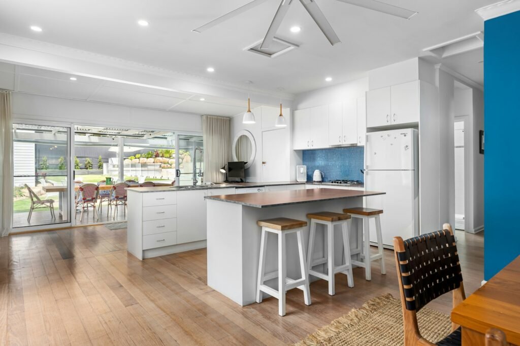 Coastal kitchen with natural wood table and ceiling fan